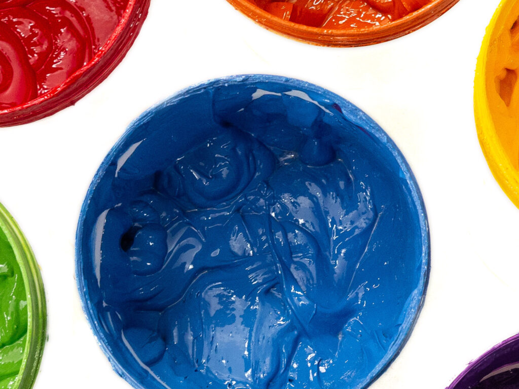 Brightly colored screen printing inks: red, blue, yellow, green.